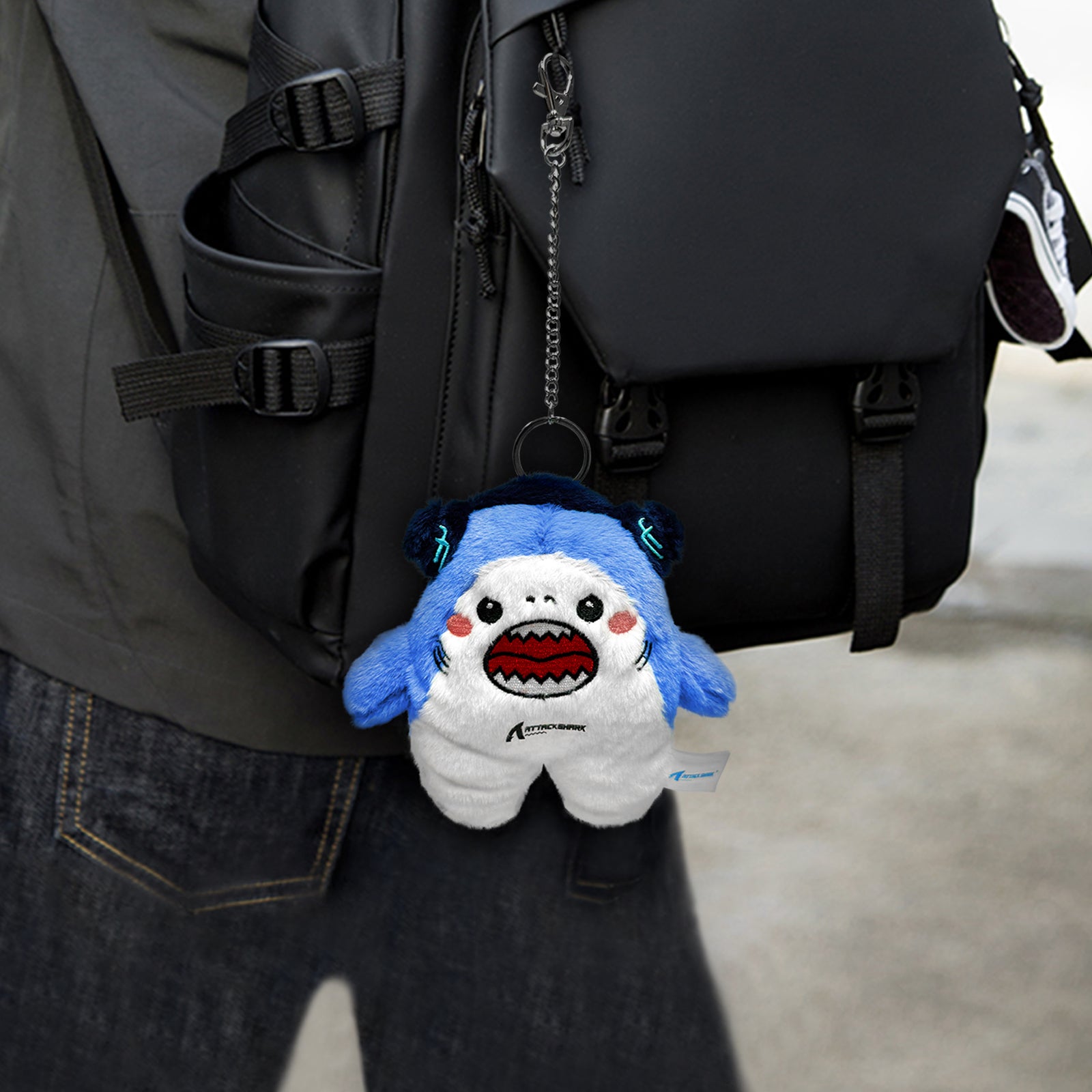 Attack Shark mascot plush toy hanging on backpack
