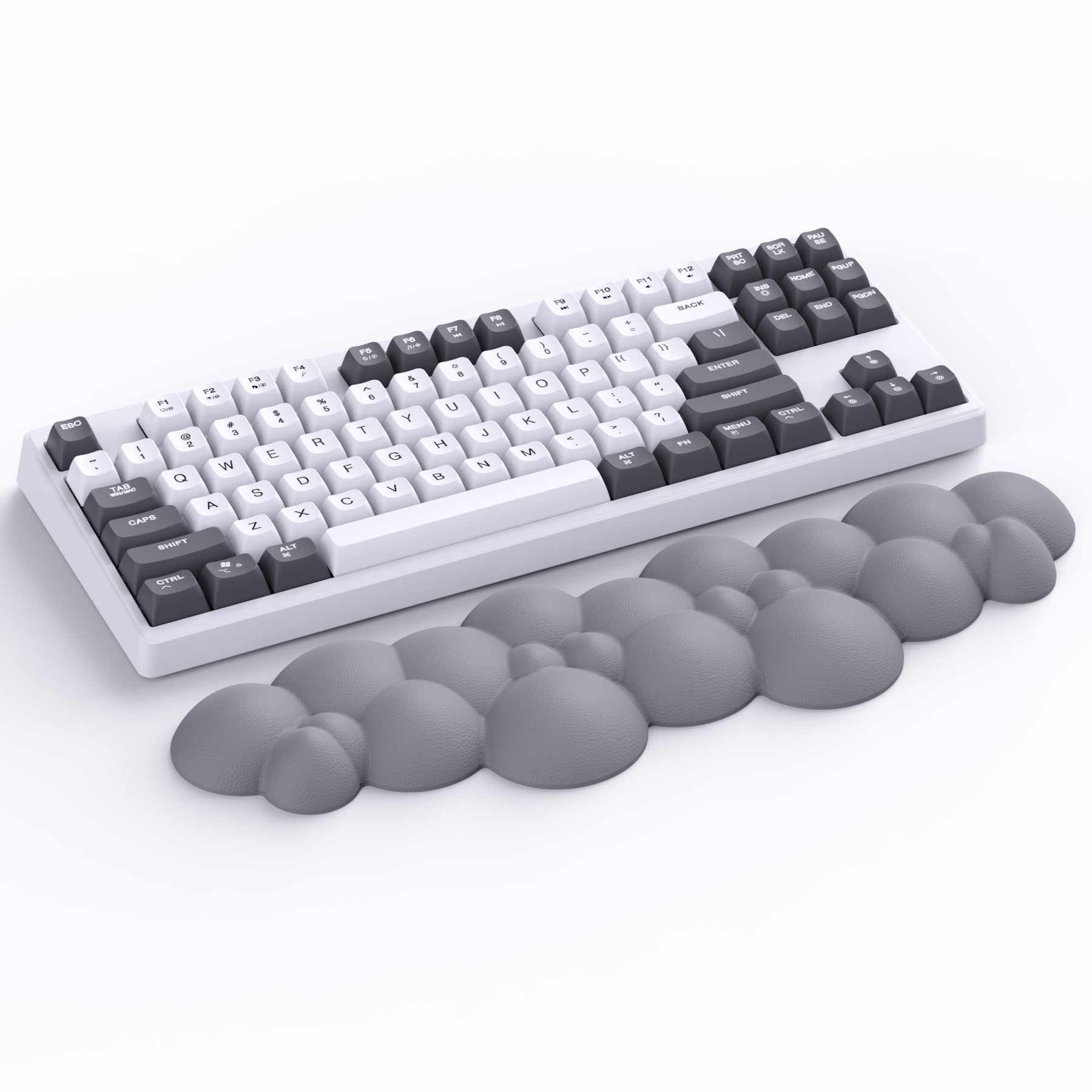 Cloud-shaped gray wrist rest beside black and white mechanical keyboard for ergonomic comfort.